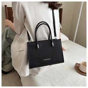 Détail du grand sac cabas noir à grain de cuir avec logo Fashion et bandoulière chic