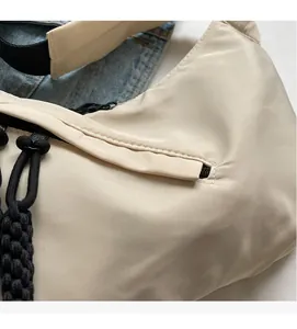 Detailed macro view of soft cream nylon fabric with black drawstring and zip closure