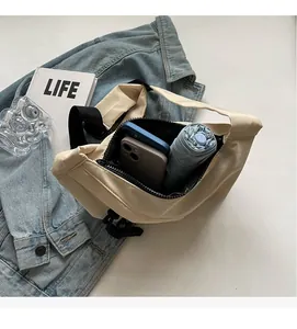 Spacious interior of beige nylon shoulder bag holding two phones and a folding umbrella