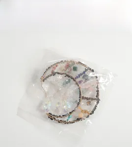 Macro shot of crescent moon suncatcher with raw natural crystal stones and gold wire wrap