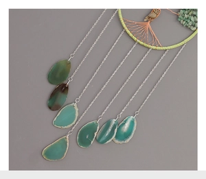 Macro detail of natural green agate slices with tree of life and owl charm wind chime