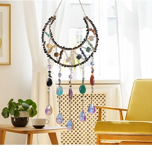 Detail of moon-shaped suncatcher with natural stones and multifaceted crystal pendant