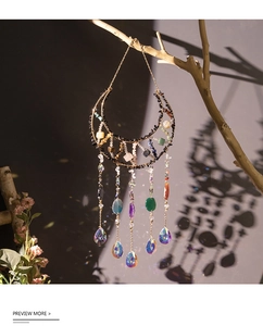 Detail of moon suncatcher casting rainbow light on wall with natural crushed stones