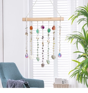 Detailed view of bohemian crystal suncatcher with natural agate slices on wooden bar