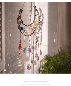 Detail of moon suncatcher with crystals and agate stones casting rainbow light