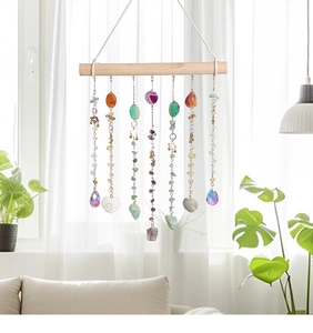 Detail of bohemian wall hanging with natural agate slices and crystals on a wooden rod