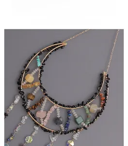 Detail of crescent moon crystal suncatcher with natural stones and gold wire wrap