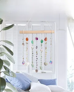 Detail of boho sun catcher with agate slices and natural crystals on a wooden bar