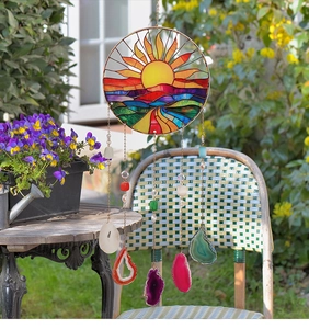 Detail of sun catcher with agate slices and tree of life hanging in garden