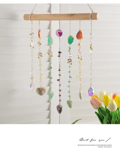 Detail of bohemian suncatcher featuring agate slices and crystals on a wooden rod