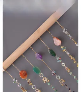 Close-up of bohemian agate crystal suncatchers with natural stone beads on a wooden rod
