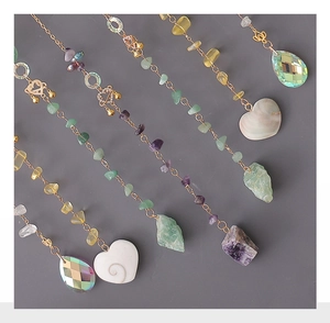 Detail of handmade crystal suncatcher featuring natural agate and gold metal chains
