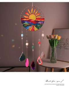Detail of a sun catcher with stained glass mountain art and natural agate slices