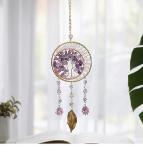 Detail of tree of life suncatcher with purple crystal stones and golden metal leaves