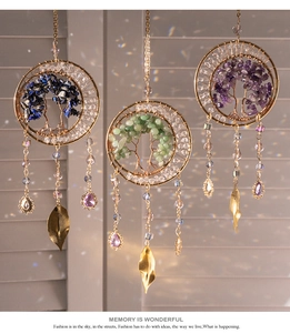 Three celestial tree of life suncatchers with natural crystals hanging on a window