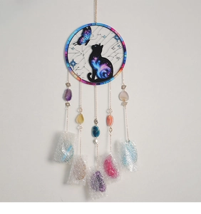 Macro detail of suncatcher featuring a black cat silhouette and natural agate stones