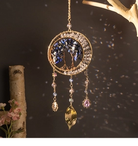 Detail of tree of life suncatcher with blue crystals and hanging golden leaf charms