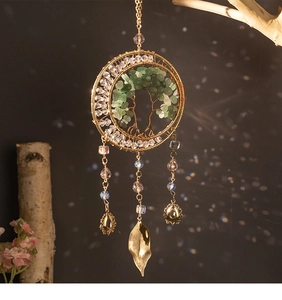 Detail of tree of life wall hanging with green stones and golden leaf on branch