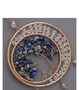 Close-up of handmade Tree of Life pendant with lapis lazuli stones and golden wire wrapping