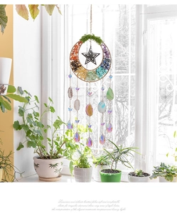 Detail eines handgefertigten Kristall-Sonnenfängers mit Natursteinen am Sonnenfenster