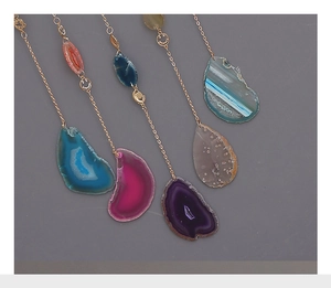 Detail of natural agate slice pendants with golden feathers and suncatcher charms