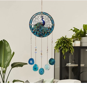 Detail of peacock suncatcher with natural agate slices and crystal beads in home setting