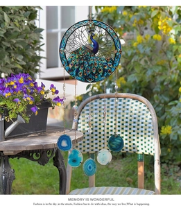 Detail of peacock suncatcher with blue agate slices in a sunlit garden setting