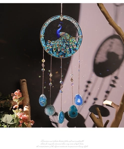 Detail of tree of life suncatcher with peacock pattern and blue agate slices