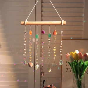 Handmade agate suncatcher with natural crystals and wood hanger showing rainbow light
