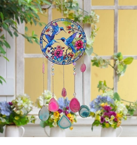 Detail of blue hummingbirds suncatcher with hanging natural agate slices and metal chains