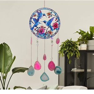 Detail of hummingbird suncatcher with hanging natural agate slices and colorful floral motifs