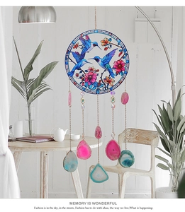 Detail of colorful suncatcher with hummingbird glass art and natural agate slices