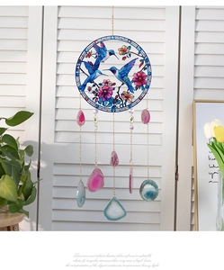 Detail of stained glass hummingbird frame with hanging natural agate slices ornaments