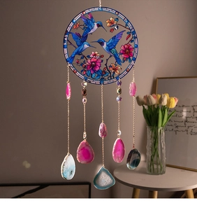 Detail of hand-painted hummingbird glass pendant with hanging natural agate slices