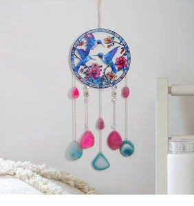 Detail of metal suncatcher with blue hummingbirds and vibrant natural agate slices