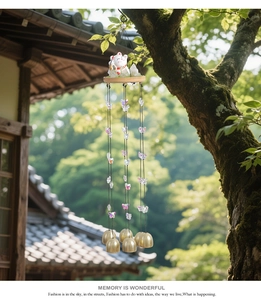 Japanese lucky cat wind chime with ceramic cat, butterfly accents, and brass bells in garden