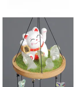 Close-up of Maneki Neko lucky cat on wood base with grass and crystal cluster details