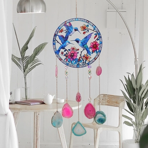 Acrylic hummingbird suncatcher with natural agate slices and crystals in a bright home