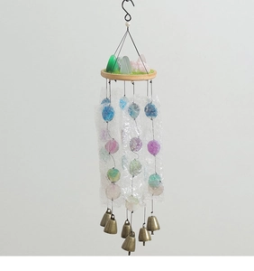 Detail view of decorative wind chime featuring colorful agate slices and bronze metal bells