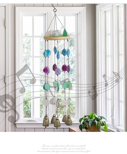Detail of agate stone wind chime with natural crystal base and five bronze bells
