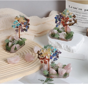 Close-up of handmade crystal trees with mixed gemstones on resin rose quartz bases