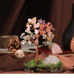 Detail of handmade crystal tree featuring colorful gemstone leaves and copper wire trunk