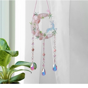 Detail of moon-shaped dream catcher with pink natural stones and crystal teardrop pendants