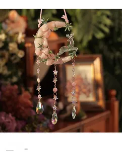 Detailed view of pink crystal moon decor with a glittery deer and star pendants