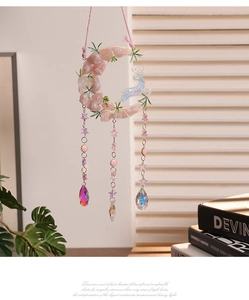 Macro detail of moon suncatcher with pink crystals, deer ornament and star charms