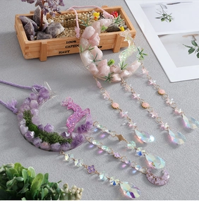Detail view of moon crystal pendant with pink gravel stones and a faceted prism drop