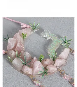 Macro view of crystal moon pendant with pink stones and deer design decor