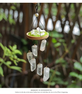 Detail of natural white crystal wind chime with bamboo base and green moss accents