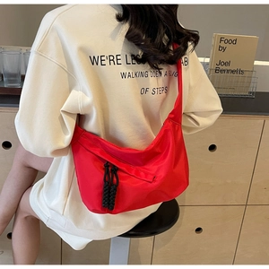 Détail du sac bandoulière croissant rouge en nylon avec tirettes de zip tressées noires
