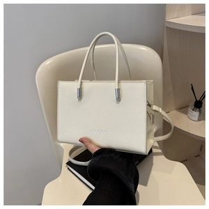 Détail du sac cabas blanc crème en cuir grainé avec logo FASHION argenté élégant